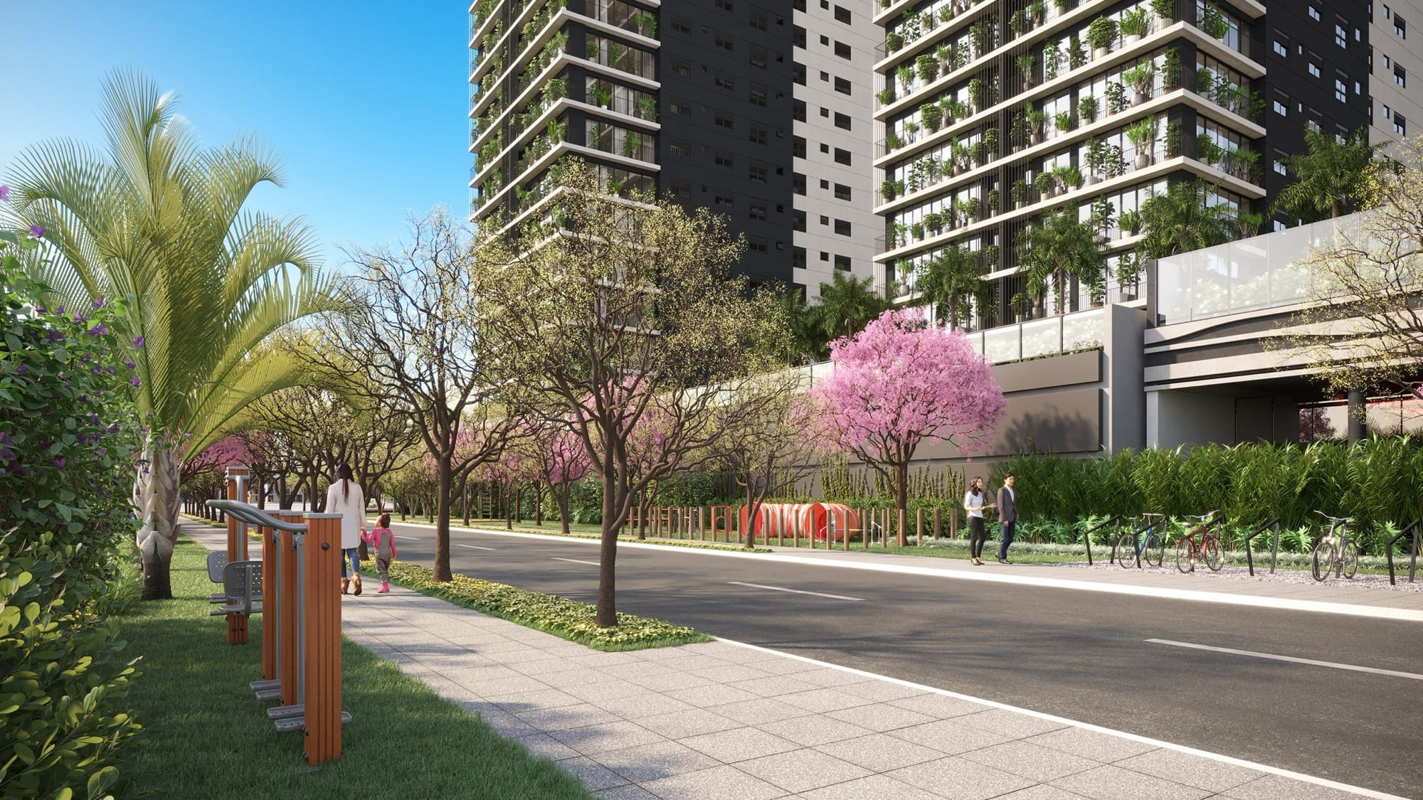 Parque linear com equipamentos de ginástica e árvores floridas junto à calçada