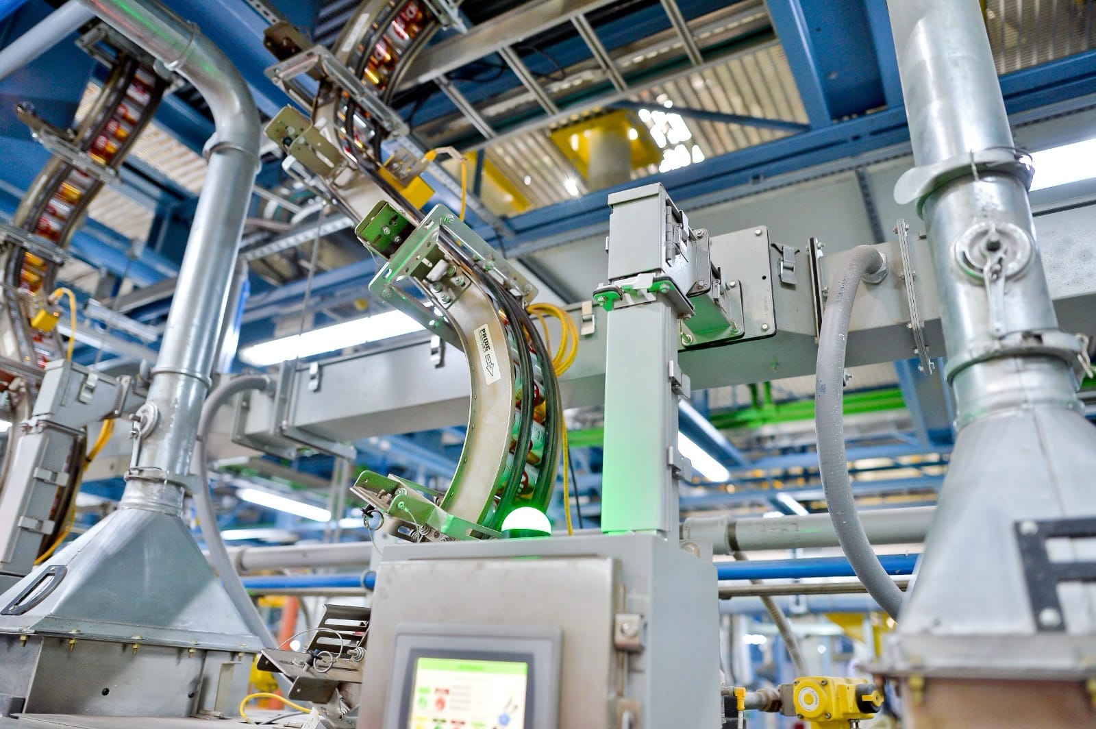 Detalhe de tubulação e painéis de controle em linha de produção industrial