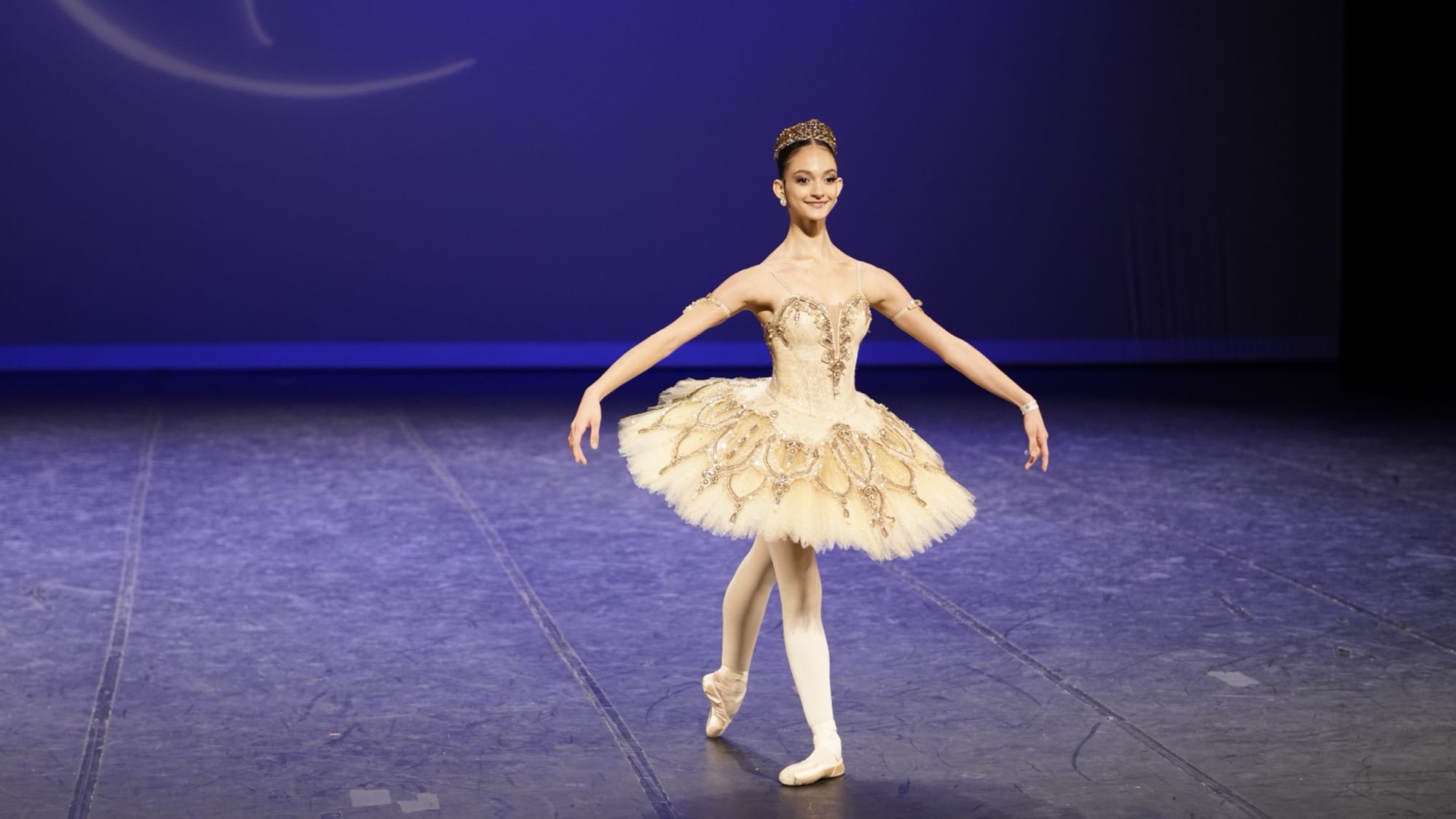 Bailarina com tutu clássico em palco iluminado