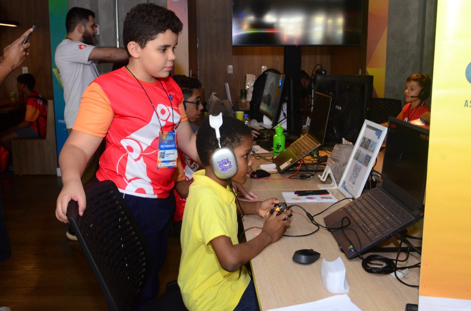 Crianças utilizando computadores e headsets em ambiente de aprendizagem