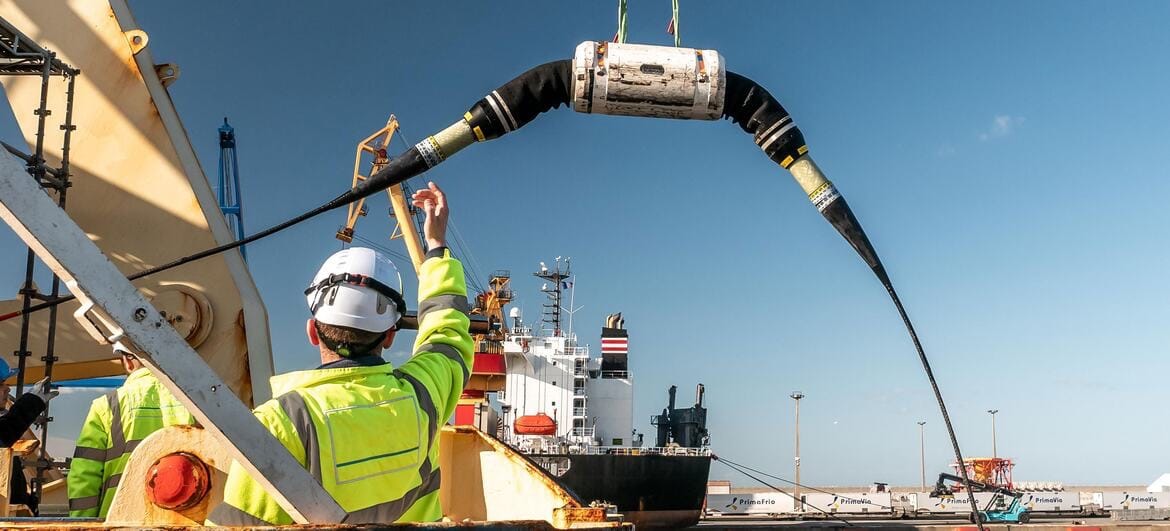 Trabalhadores em cima de um navio manipulando um cabo submarino