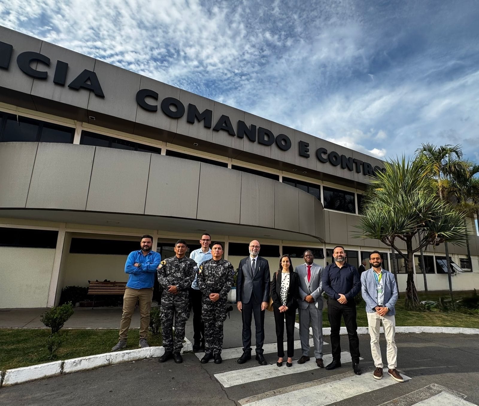 Fachada com letras 'Comando e Controle' e grupo em frente