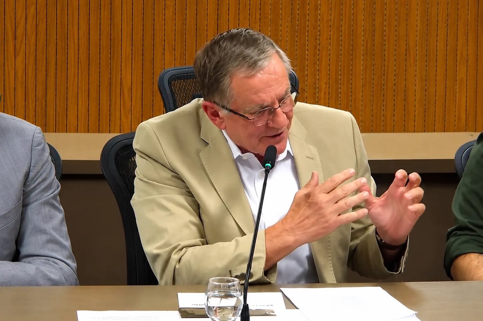 Parlamentar falando em audiência pública, microfone à frente