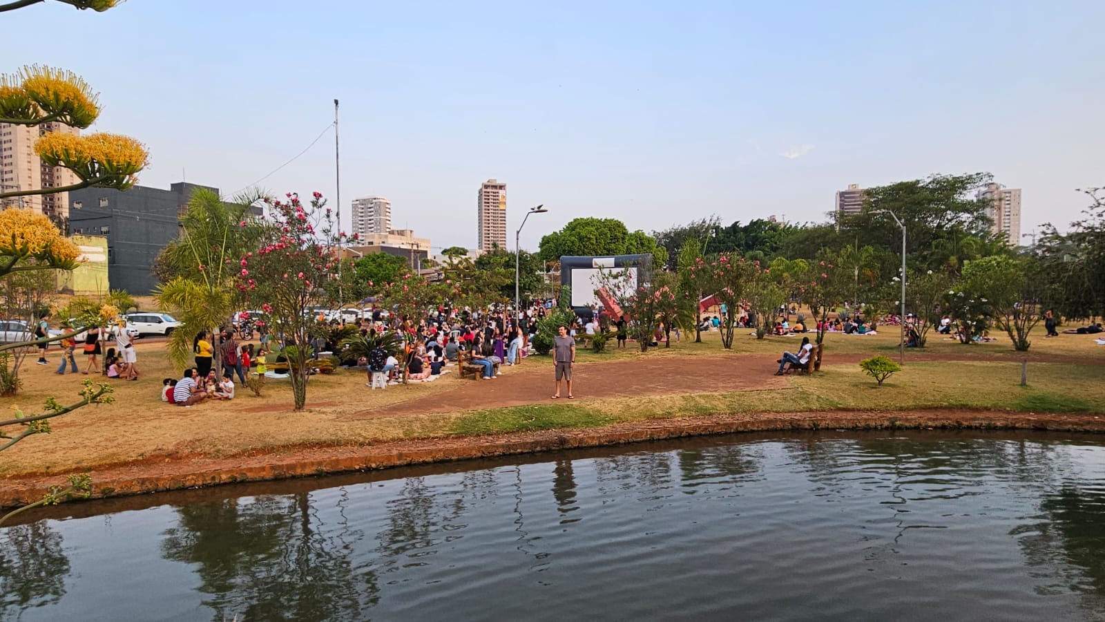 Visão ampla do parque com público e tela de projeção ao fundo