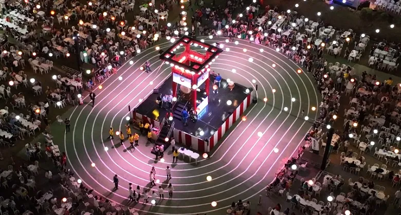 Palco iluminado de festival japonês com público; celebração dos 70 anos do Kaikan