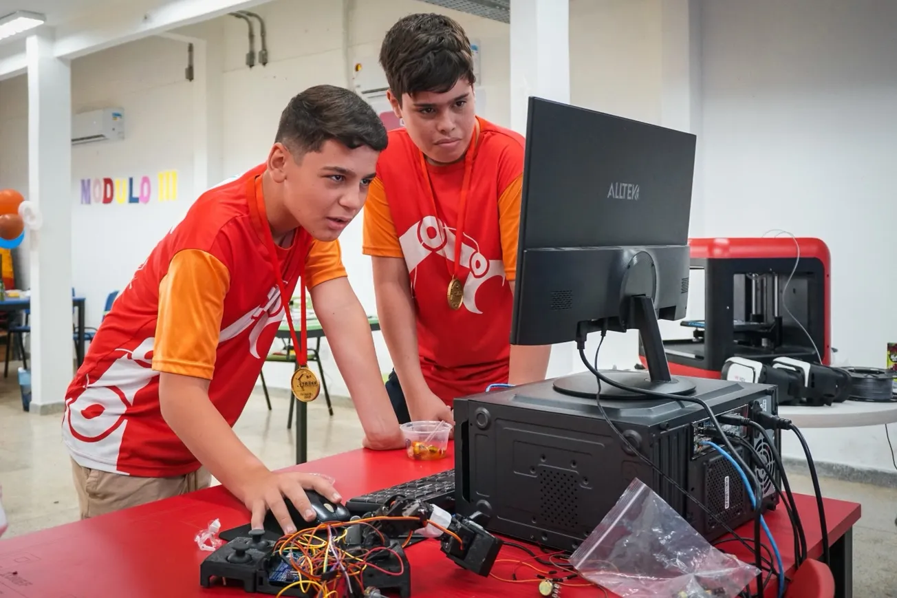 Alunos em laboratório do programa Start manuseando componentes eletrônicos e computadores