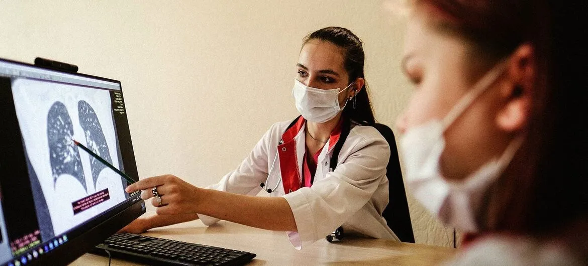 Médica apontando radiografia; comprimidos em palma da mão; paciente em leito hospitalar