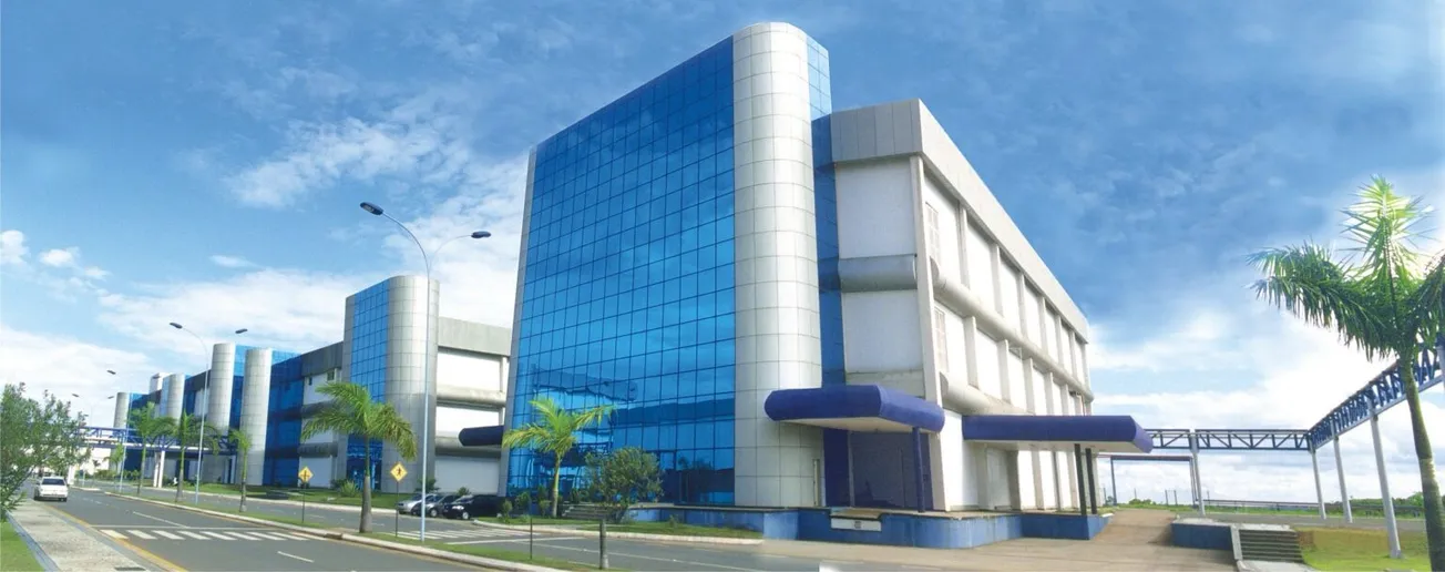 Fachada de instalação farmacêutica com vidros azuis e áreas externas