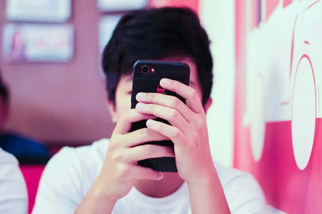 Pessoa segurando smartphone com foco nas mãos e na tela