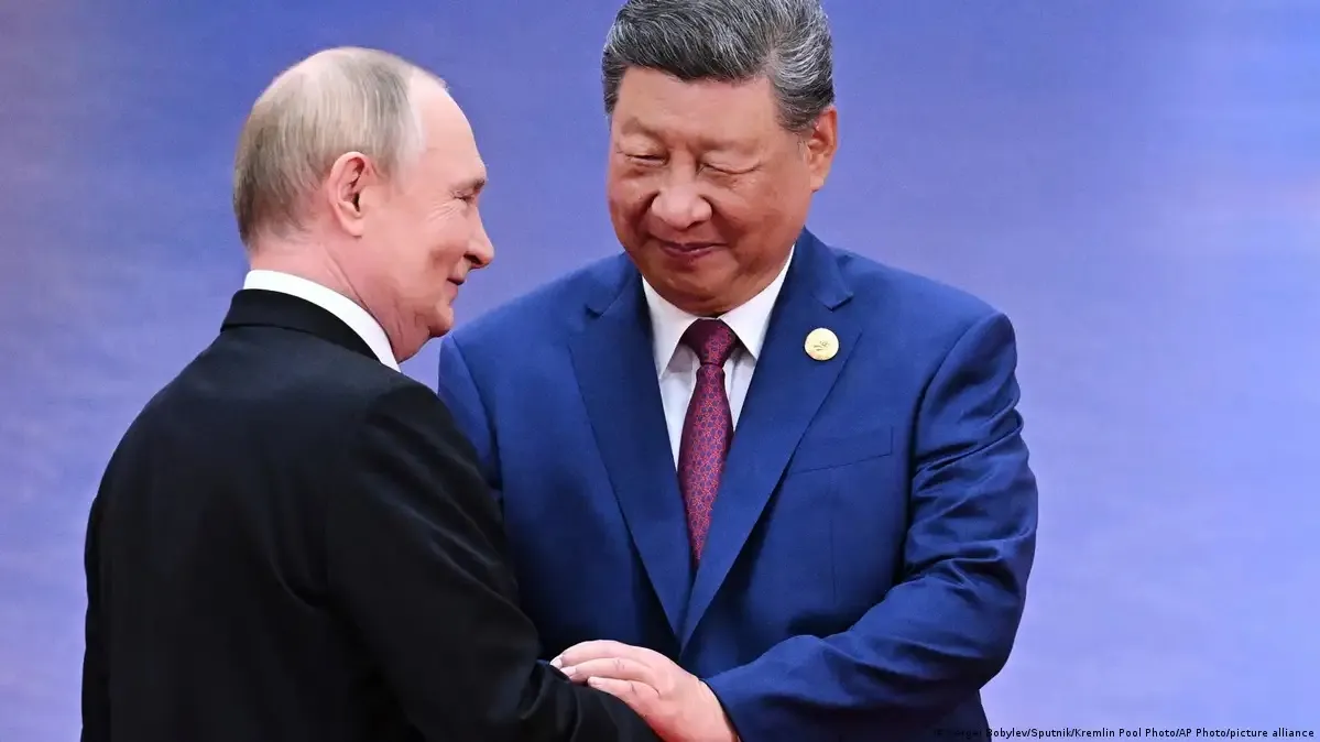 Dois líderes em cumprimento durante encontro diplomático em palco oficial; segundo registro, reunião em Pequim ilustra laços bilaterais entre os países